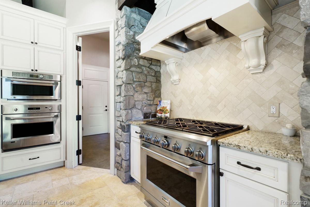 2777 South Addison Circle Rochester, MI 48306 - Photo 36 of 85 Gorgeous Chef's Kitchen with Stainless Steel Appliances, detailed hood fan with corbels, stone back splash, granite counter tops and so much more.