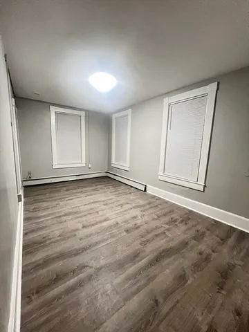 an empty room with wooden floor and window