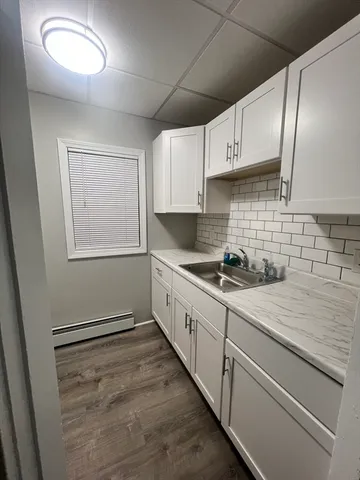 a kitchen with granite countertop white cabinets and white appliances