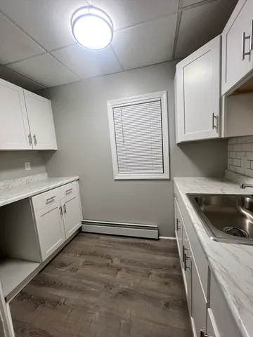a kitchen with granite countertop white cabinets and white appliances