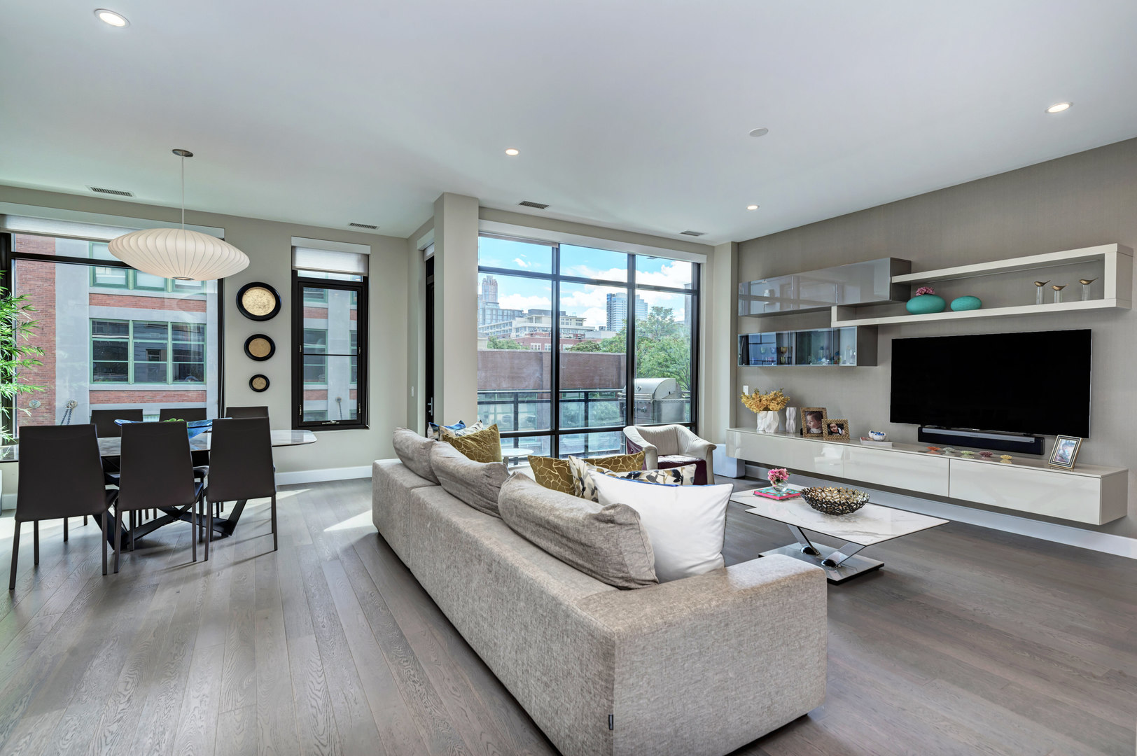 28 North Carpenter Street, Unit 3S Chicago, IL 60607 - Photo 11 of 37 a living room with furniture floor to ceiling window hardwood floor and a flat screen tv