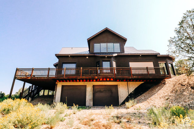 985 Russell Road Hatch, UT 84735 - Photo 1 of 30 Rear view of house featuring a deck, a metal roof, stairs, dirt driveway, and a garage