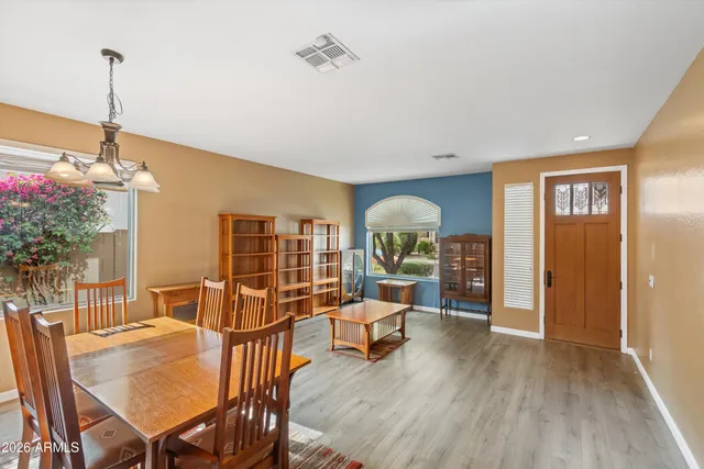 a dining hall with stainless steel appliances kitchen island granite countertop a dining table and chairs