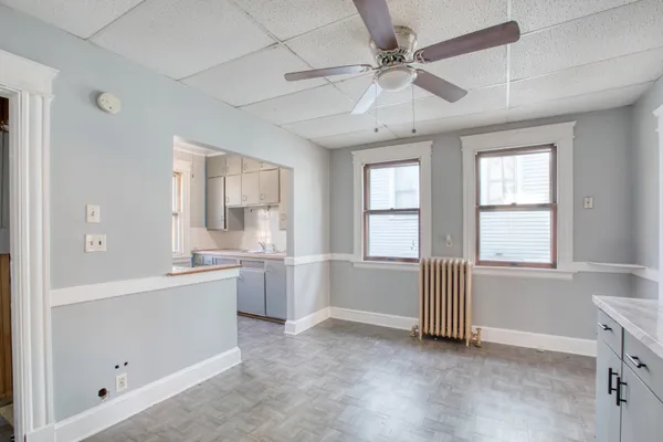 a large white kitchen with granite countertop a sink and dishwasher with white cabinets