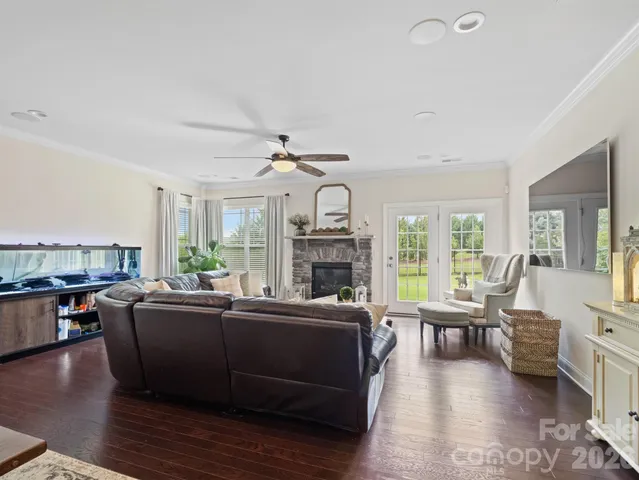 a living room with fireplace furniture and a large window