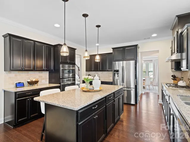 a kitchen with stainless steel appliances granite countertop a sink a stove and a refrigerator