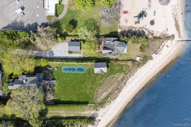 a view of a house with a yard and a large tree