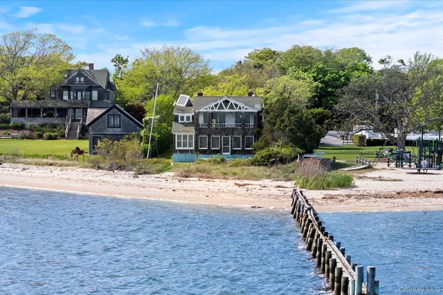a front view of a house with a garden and trees