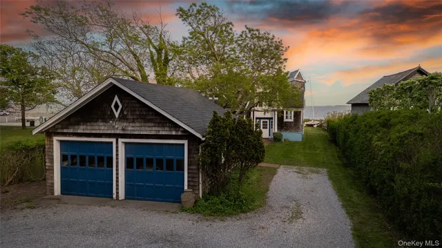a view of a lake with a table and chairs under an umbrella