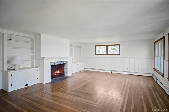 a view of empty room with a fireplace and wooden floor