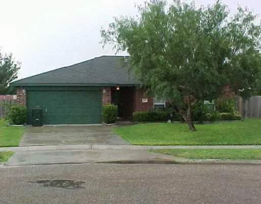 a front view of a house with a yard and trees