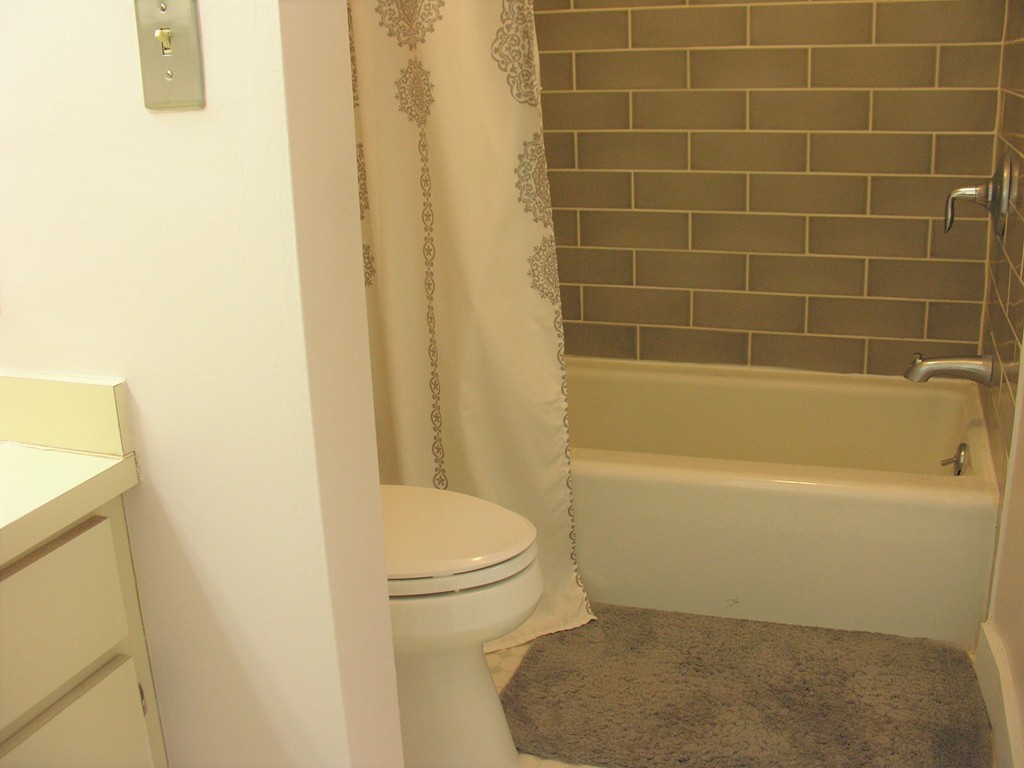 78 Mountain Gate Road, Unit 78 Ashland, MA 01721 - Photo 12 of 17 a white bath tub sitting next to a white toilet and a sink
