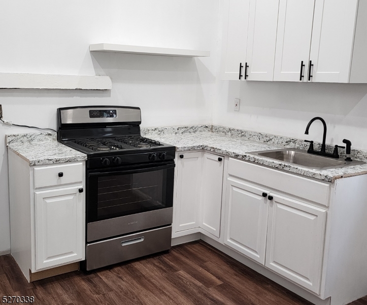 a kitchen with granite countertop white cabinets and appliances