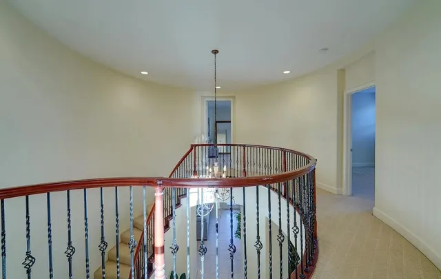 a view of staircase with railing and a chandelier
