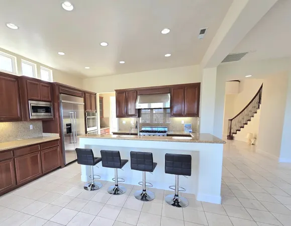 a kitchen with stainless steel appliances kitchen island granite countertop a sink and cabinets