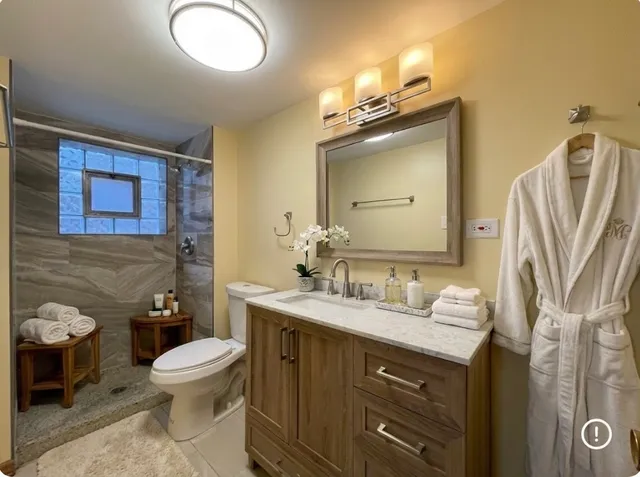 a bathroom with a granite countertop toilet sink and mirror