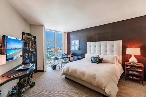 a bedroom with a bed window and a flat screen television