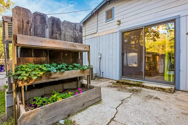 a view of a house with a yard and potted plants