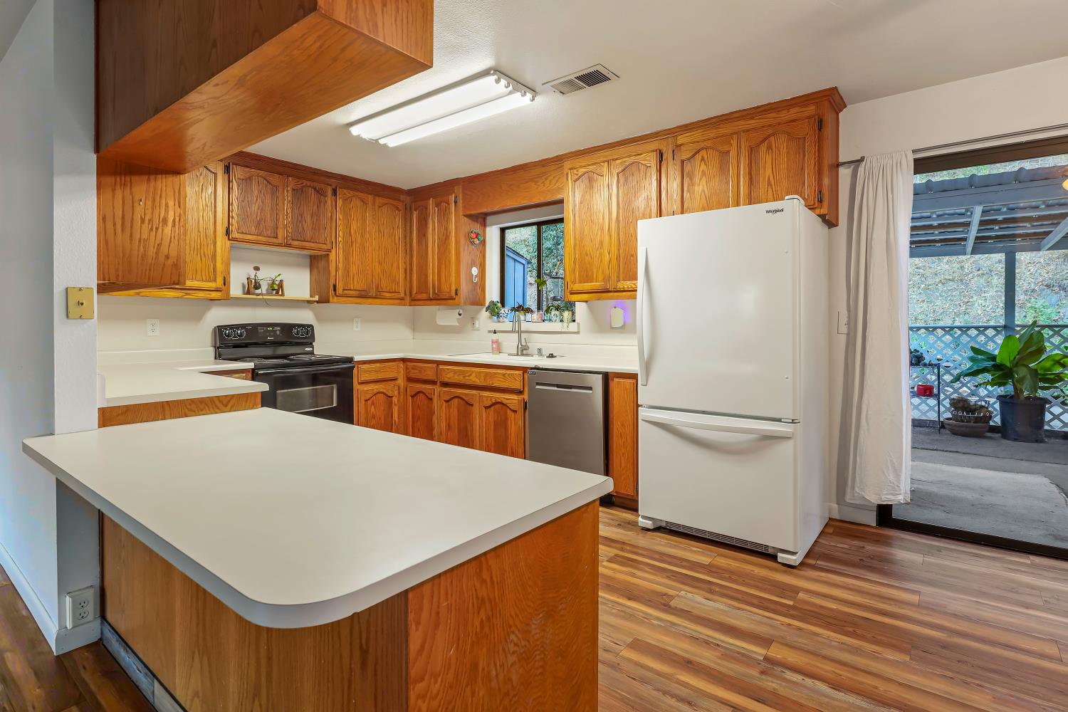 9174 State Rte 26 Mokelumne Hill, CA 95245 - Photo 7 of 52 a kitchen with a refrigerator a stove a sink and a microwave