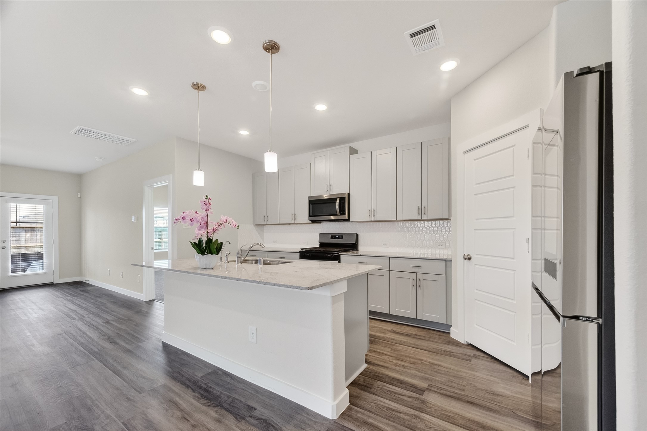 12119 Rushing Rdg Drive Baytown, TX 77523 - Photo 14 of 48 a kitchen with white cabinets and stainless steel appliances