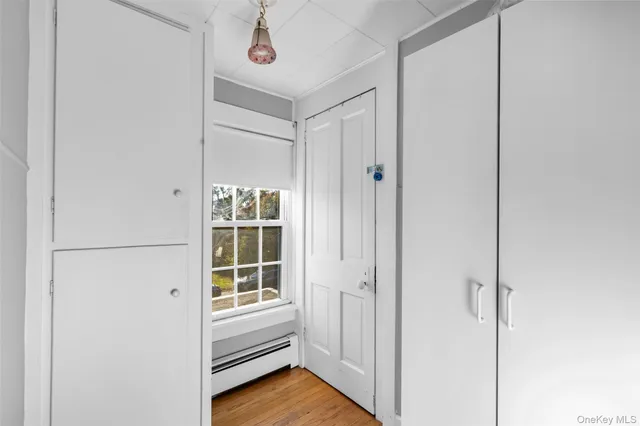 a view of a hallway with closet and a window