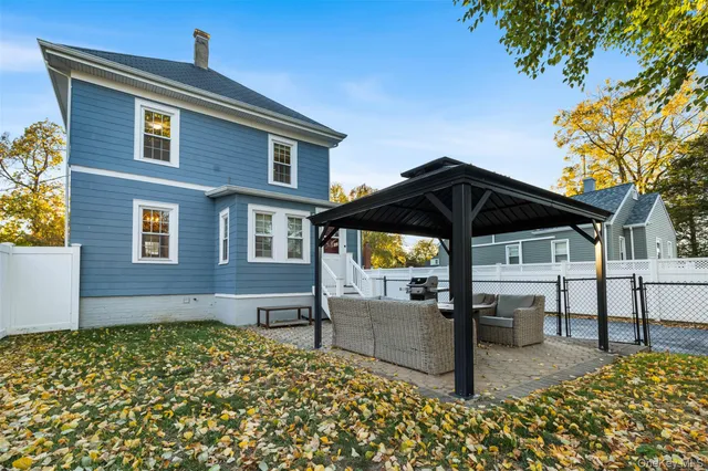 a view of a house with backyard and sitting area