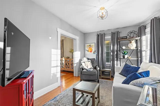 a living room with furniture a rug and a flat screen tv