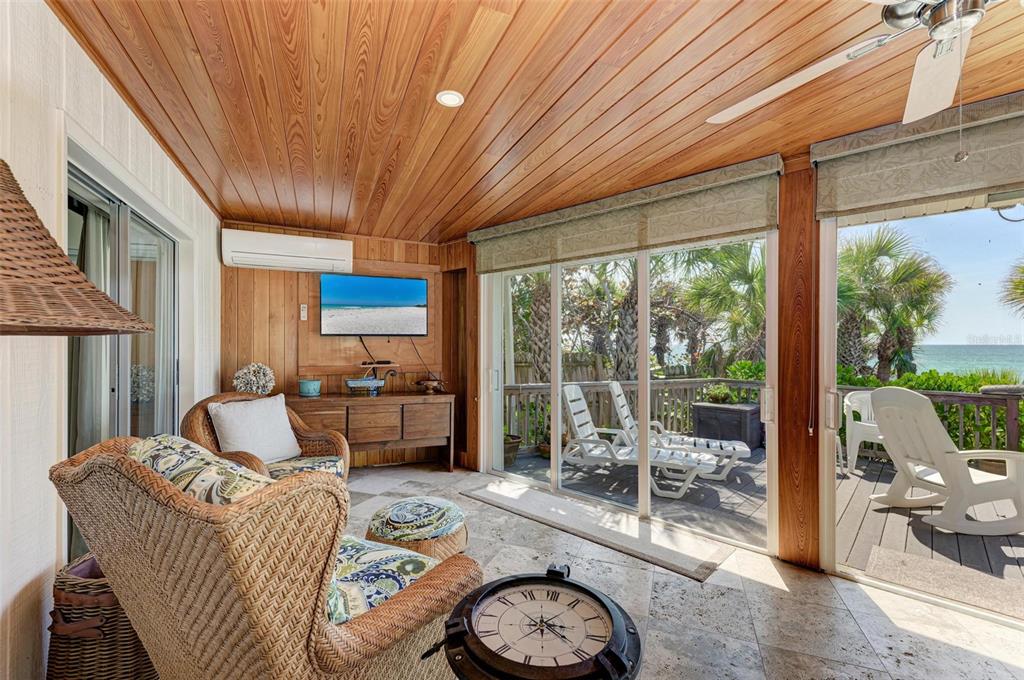 8320 Manasota Key Road Englewood, FL 34223 - Photo 38 of 58 a living room with furniture a fireplace and a floor to ceiling window