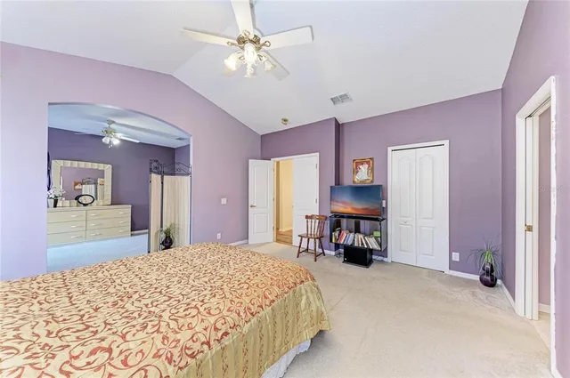 a bedroom with a large bed and a chandelier