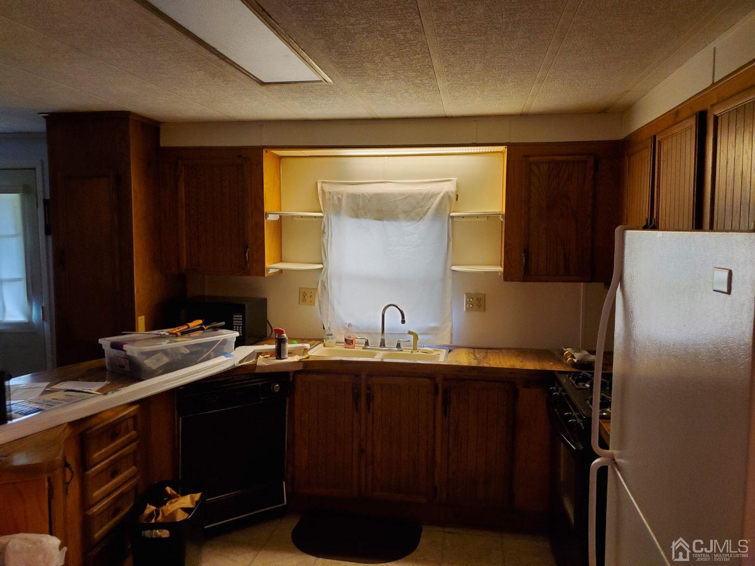 35 Dickens Road North Brunswick, NJ 08902 - Photo 6 of 15 a kitchen with a sink a refrigerator and cabinets