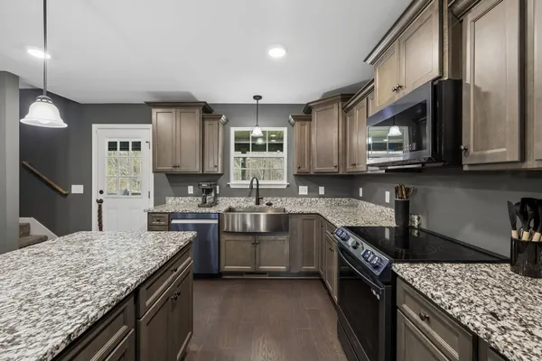 a bathroom with a granite countertop sink a toilet and a large mirror