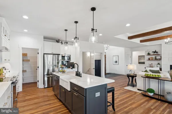 a kitchen with stainless steel appliances kitchen island a large counter top space a sink and a wooden floor