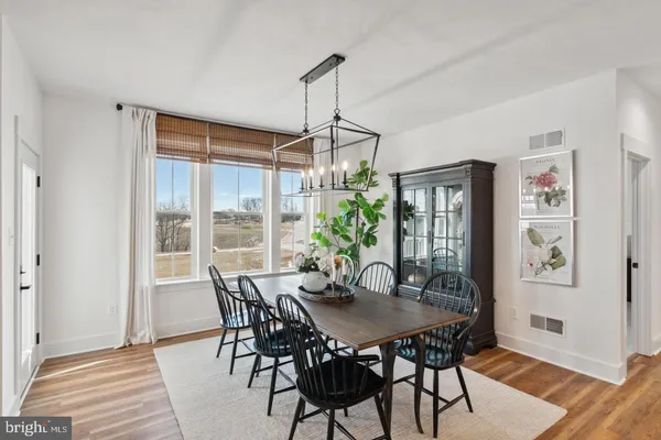 a dining room with furniture window and wooden floor