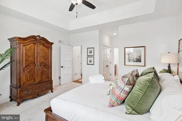 a spacious bedroom with a bed and a chandelier