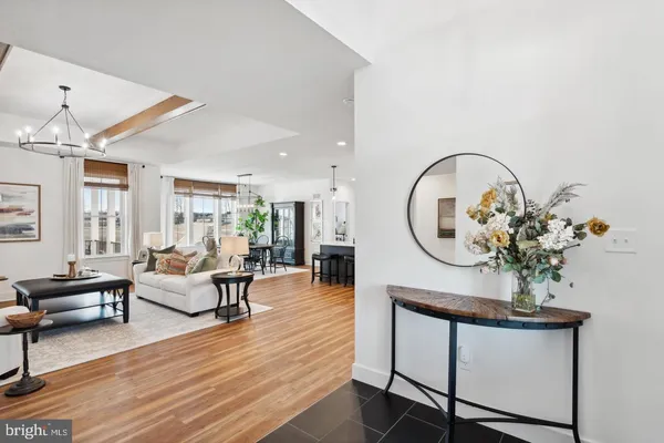 a living room with furniture a large window and wooden floor