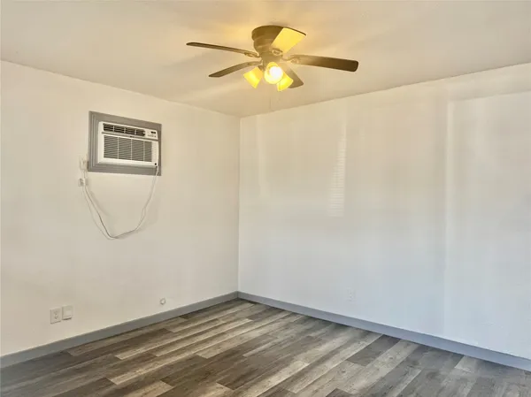 a view of an empty room with closet and a window