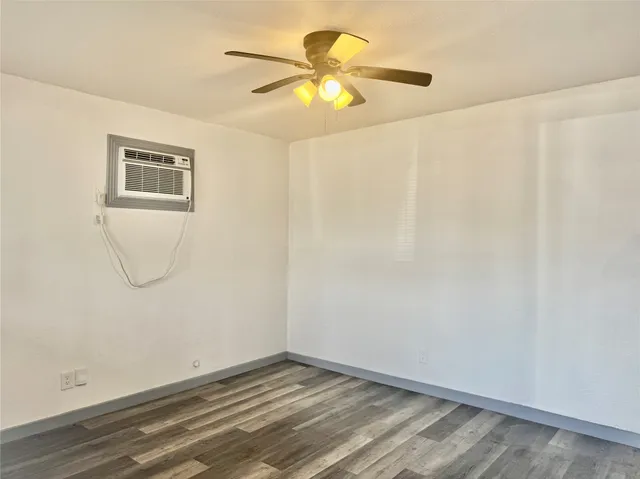 a view of an empty room with closet and a window