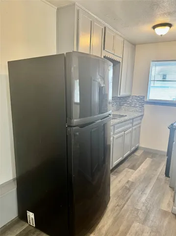 a sink with granite countertop cabinets