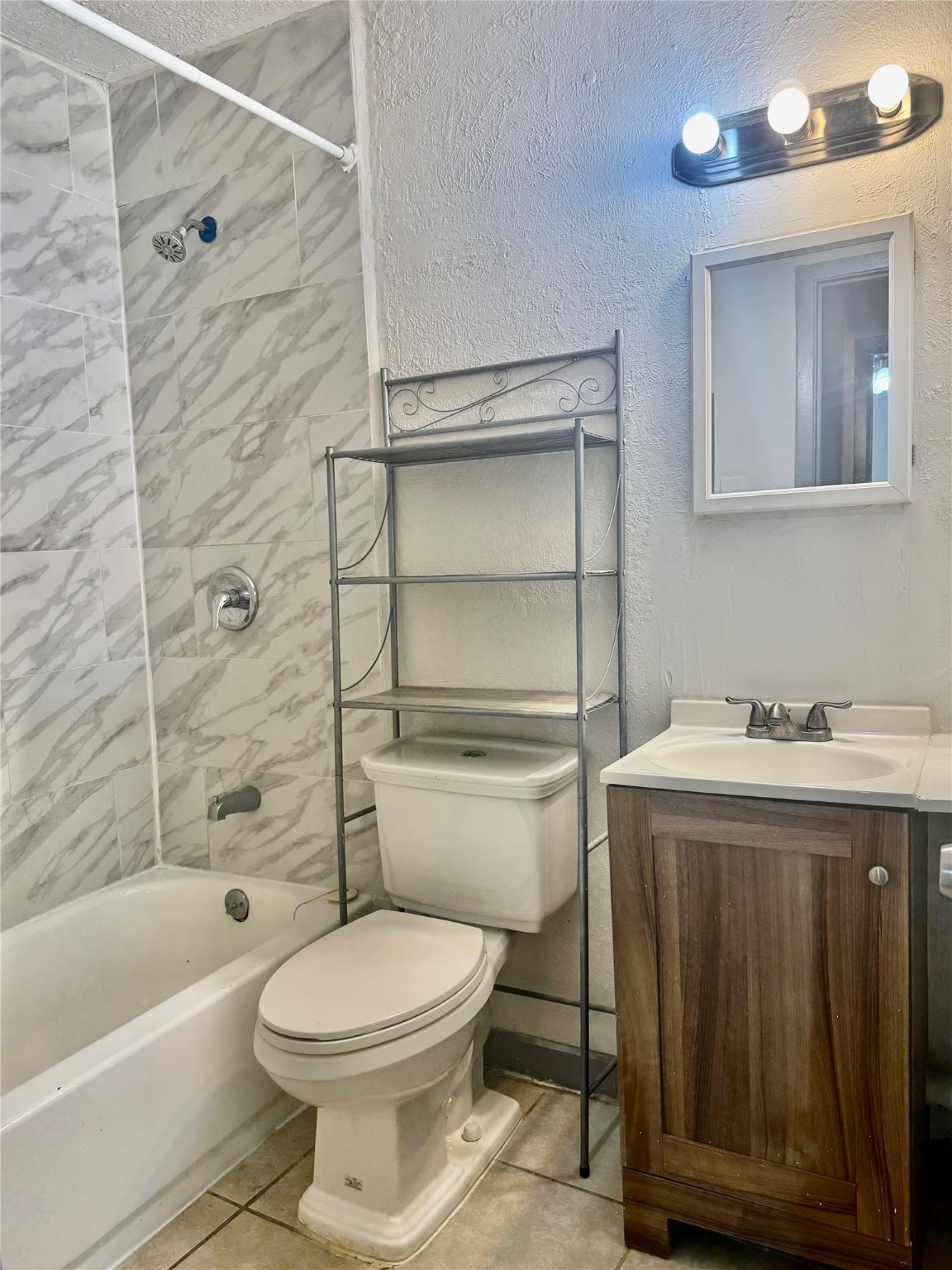 1001 Spooner Street, Unit C Pasadena, TX 77506 - Photo 7 of 9 a bathroom with a toilet sink vanity tub and shower