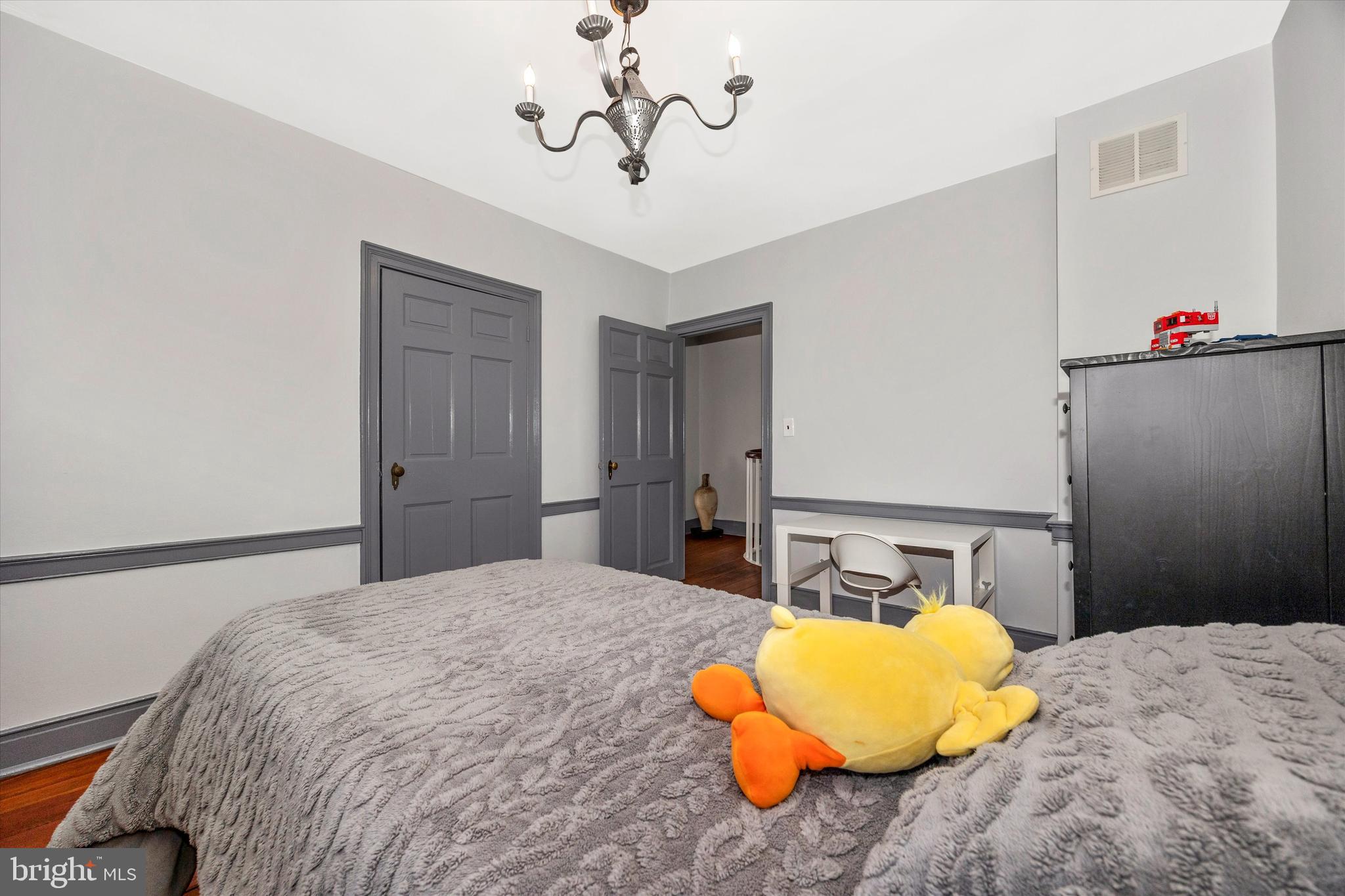 73 West Main Street New Market, MD 21774 - Photo 27 of 44 a bedroom with a bed and a chandelier