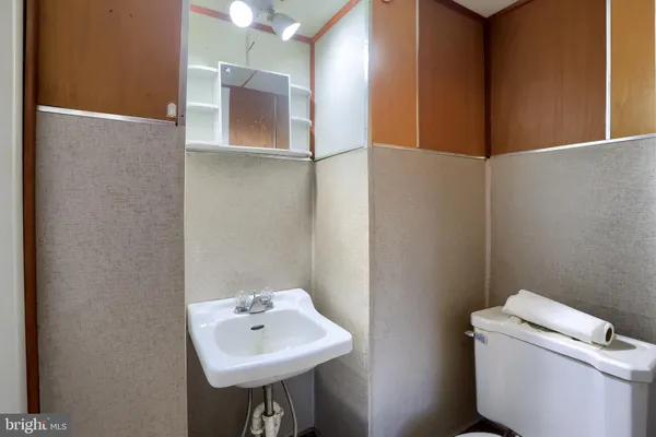 a bathroom with a toilet sink and mirror