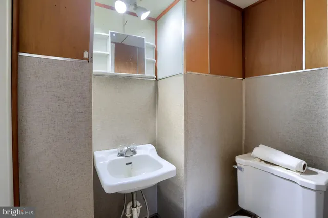a bathroom with a toilet sink and mirror