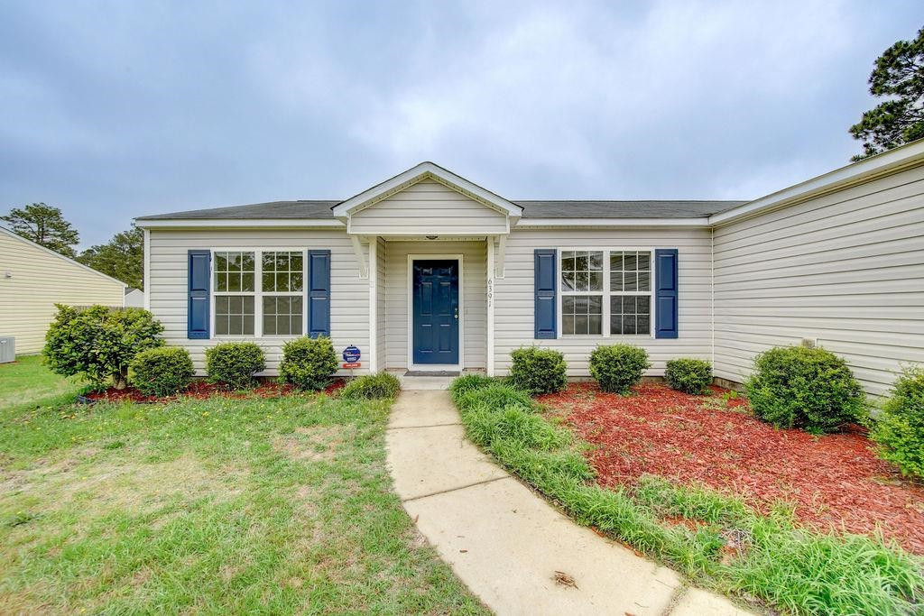 6391 Overhills Road Spring Lake, NC 28390 - Photo 2 of 15 a front view of a house with garden
