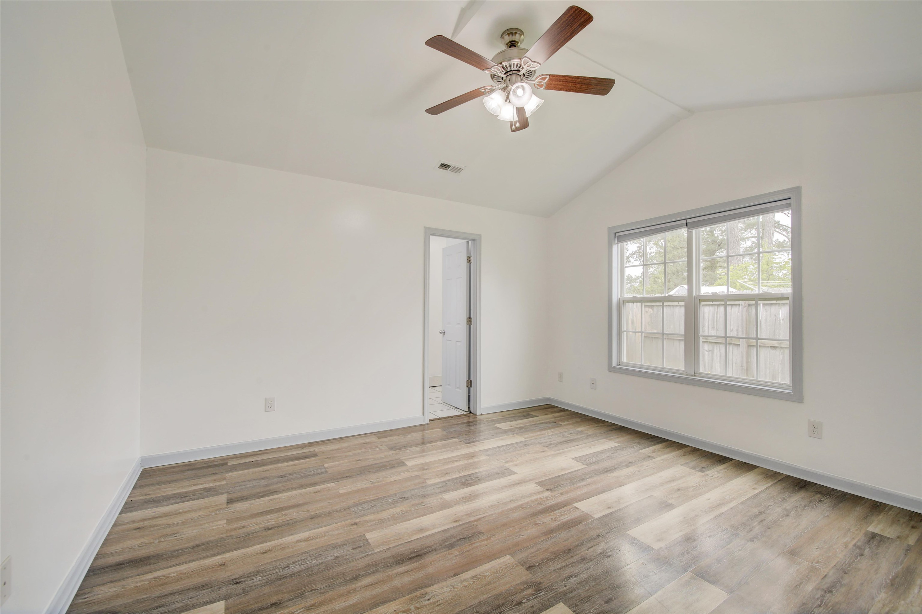 6391 Overhills Road Spring Lake, NC 28390 - Photo 6 of 15 an empty room with wooden floor chandelier fan and windows