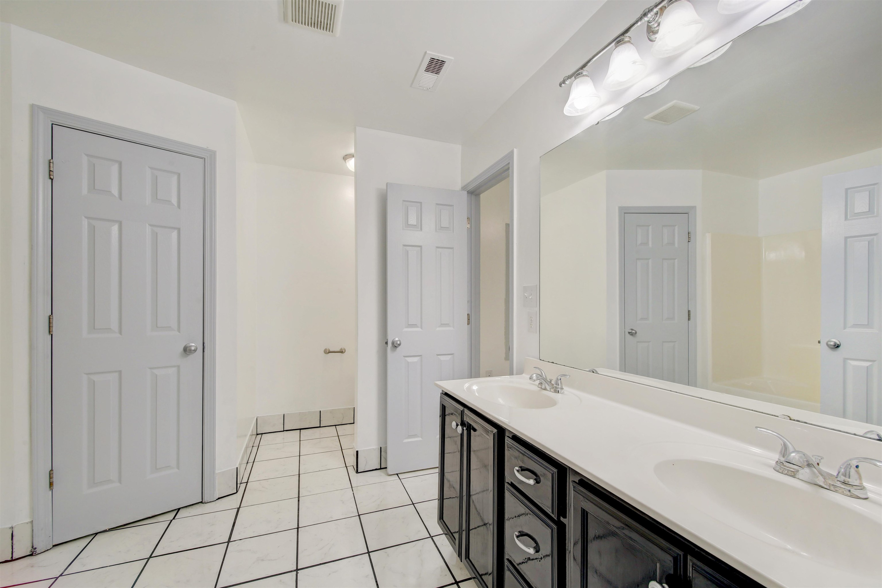 6391 Overhills Road Spring Lake, NC 28390 - Photo 7 of 15 a spacious bathroom with a double vanity sink a mirror and a shower