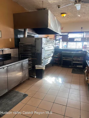 a kitchen with granite countertop a refrigerator and a stove top oven