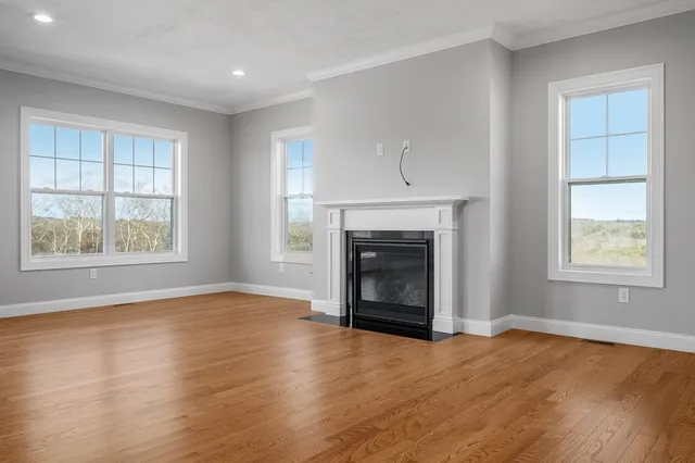 an empty room with windows and fireplace