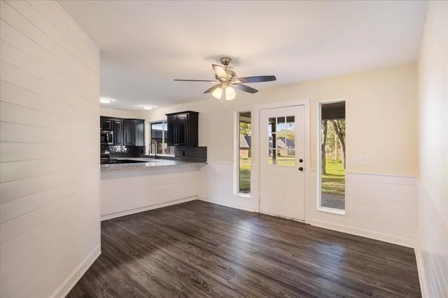 a view of a kitchen and a kitchen with wooden floor and a ceiling fan