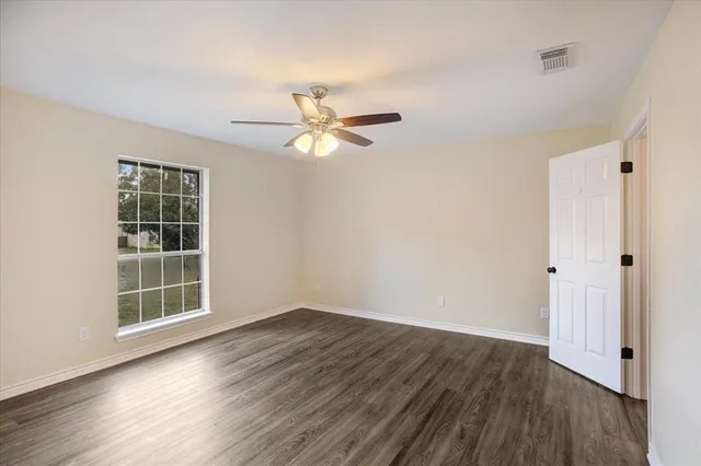 wooden floor in an empty room with a window
