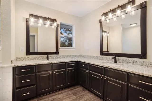 a bathroom with a granite countertop sink double and mirror